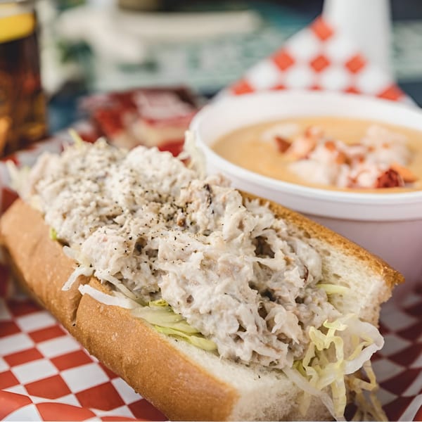 A Maine-ly Sandwiches lobster roll with shredded lettuce and a side of lobster bisque.